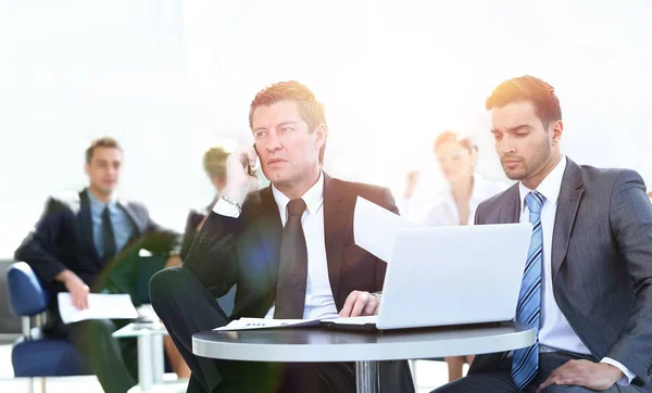 Seriöser Geschäftsmann telefoniert am Schreibtisch — Stockfoto