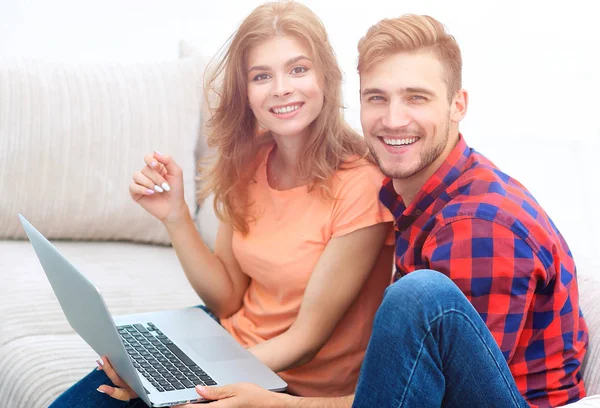 Paar studenten met een laptop zittend op de bank — Stockfoto