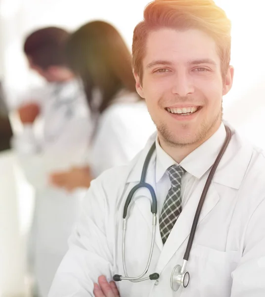 Joven doctor en el fondo de colegas — Foto de Stock