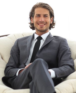 Kendine güvenen işadamı büyük bir rahat sandalyede oturuyor.