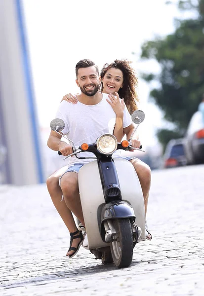 Feliz joven pareja montando un scooter en la ciudad en un día soleado —  Fotos de Stock