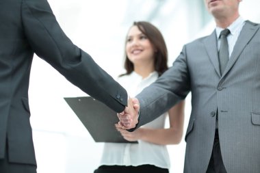 Otururken gülümseme ile el sıkışan iki yakışıklı erkekler