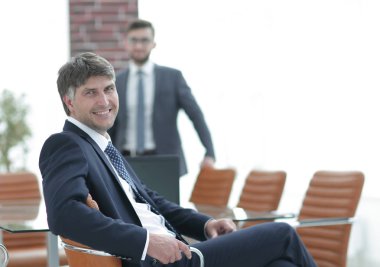 Bir boş toplantı odasında oturan işadamı