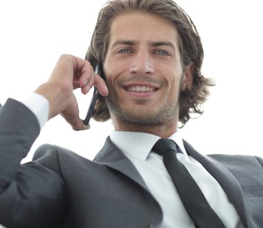 iş adamı rahat bir sandalyede otururken Smartphone'da konuşuyor.