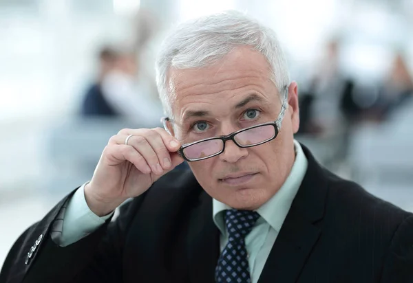 Gros plan d'un homme d'affaires senior ajustant ses lunettes — Photo