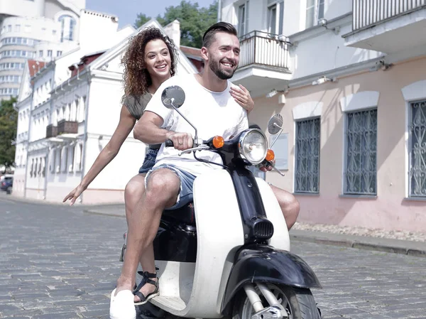 Happy young couple having fun on a scooter — Stock Photo, Image