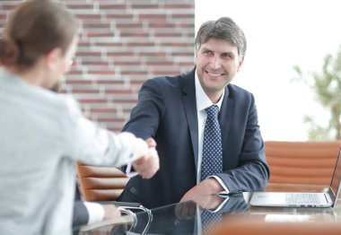 Masadaki iş adamlarının el sıkışması.