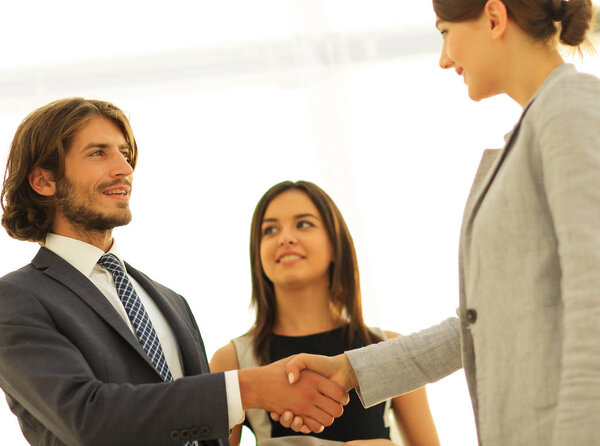 Бизнесмены пожимают руки в комнате с большим оконным туалетом