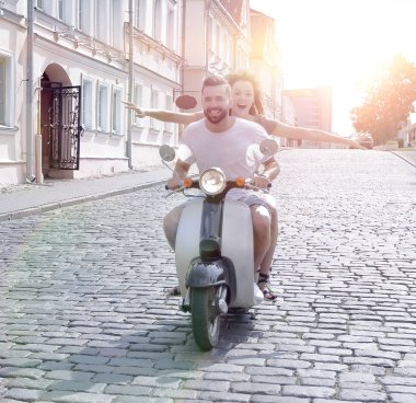 mutlu genç bir çift bir scooter üzerinde eğleniyor