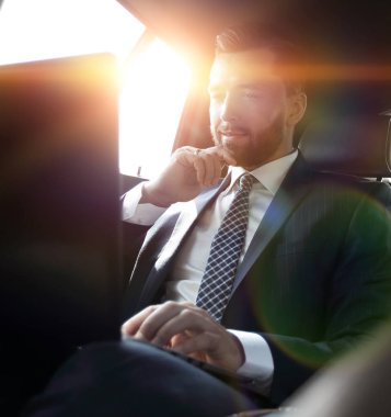 İşadamı dizüstü bilgisayarla çalışıyor ve pencereden dışarı bakıyor. 