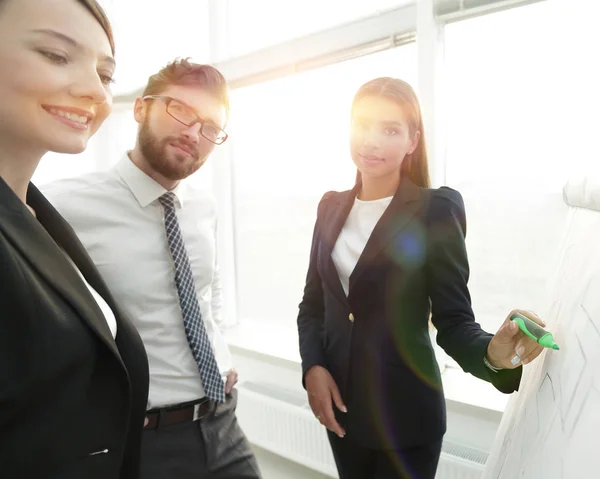 Geschäftsfrau zeigt mit Filzstift auf Flipchart — Stockfoto