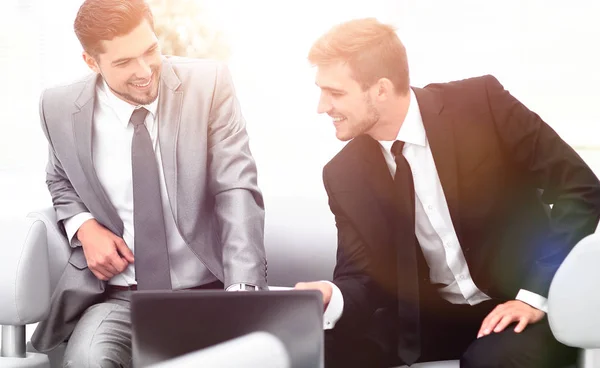 Zwei Kollegen am Laptop sitzen in der Lobby des Büros. — Stockfoto