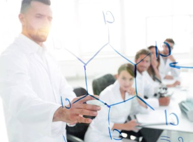 Camın arkasından. Laboratuarda blackboard yakın duran bir bilim adamı.