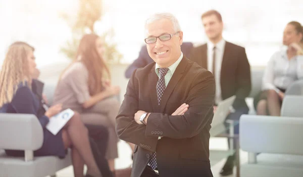 Lächelnder Senior-Geschäftsmann im Hintergrund des Business-Teams — Stockfoto