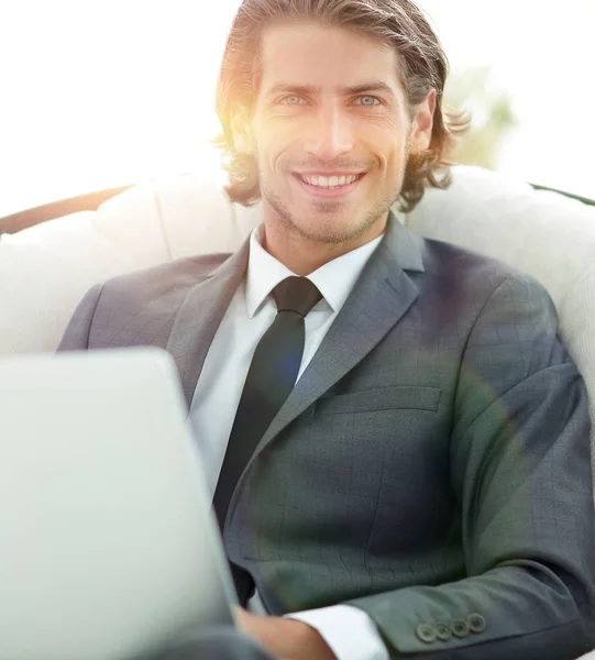 Κοντινό πλάνο του χαμογελώντας επιχειρηματίας που εργάζεται με το laptop στο σαλόνι. — Φωτογραφία Αρχείου