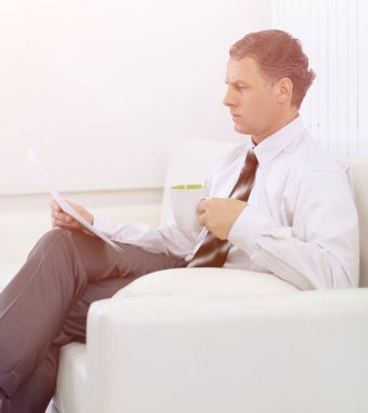 h bir sandalyede otururken bir belgeyi okurken iş adamı