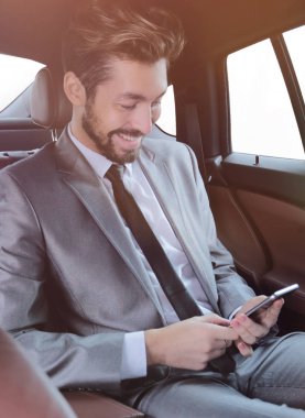 arabada oturan ve akıllı telefon mesajları okuma takım elbiseli adam
