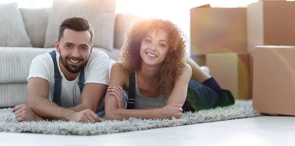 Ευτυχισμένο ζευγάρι έγκειται στο πάτωμα σε ένα νέο διαμέρισμα — Φωτογραφία Αρχείου