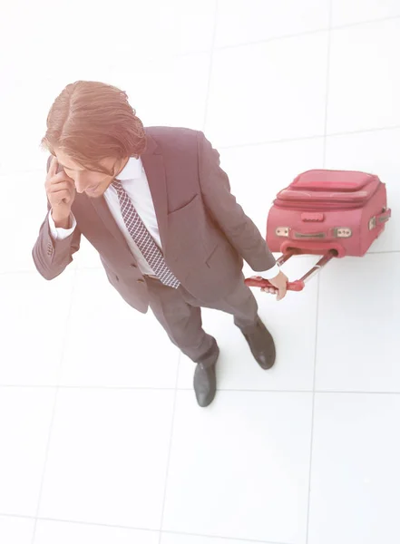 Uomo d'affari con valigia da viaggio che parla al telefono . — Foto Stock