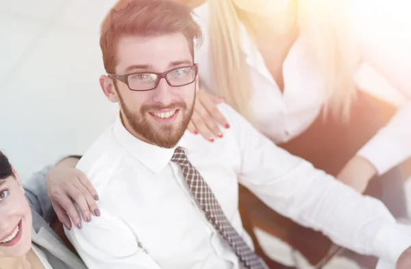 Equipe de negócios bem sucedida sentado à mesa e olhando para a câmera . — Fotografia de Stock