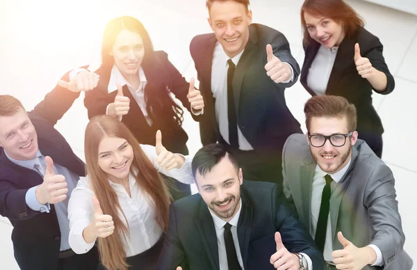 Exitoso equipo de negocios sosteniendo un pulgar hacia arriba — Foto de Stock