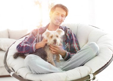 yakışıklı olan büyük bir koltukta oturan bir köpekle.