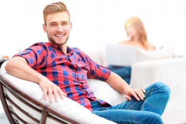 büyük sandalyede oturan genç adam