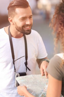 Genç çift mutlu görünürken bir rehbere bakıyor.