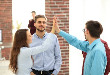 Yaratıcı iş adamları toplantı odasında beşlik çakıyor..