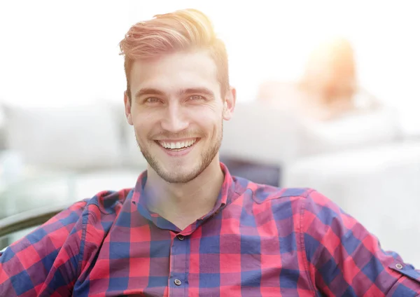 Closeup portret van een jonge man, zittend in een stoel — Stockfoto