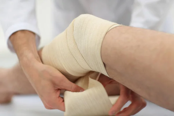 Fechar. médico bandagem uma perna pacientes — Fotografia de Stock
