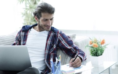 Kendine güvenen adam evde laptop ile çalışma.