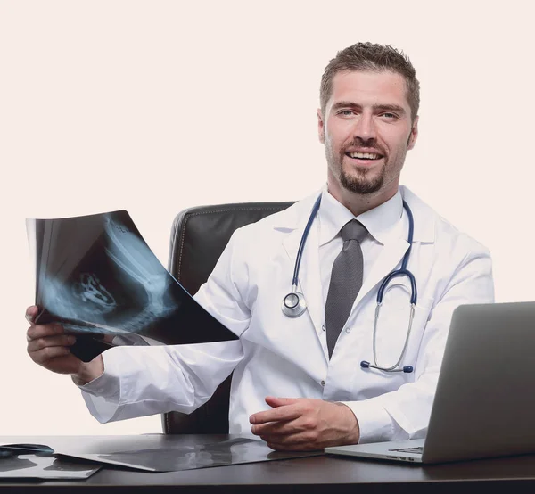 Dokter onderzoekt een x-Vleug, zitten achter een bureau — Stockfoto