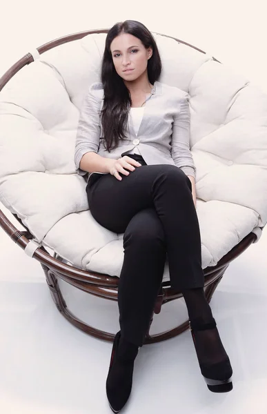 Nowoczesna młoda kobieta siedzi w okrągłym, przytulnym fotelu — Zdjęcie stockowe