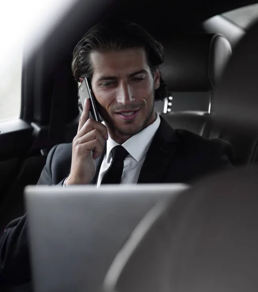 Bello uomo d'affari che utilizza il telefono cellulare in auto . — Foto Stock