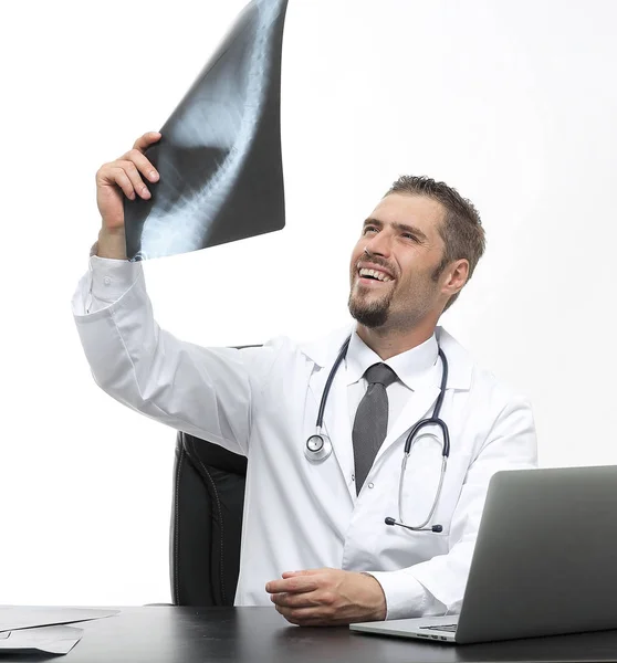 Médecin examine une radiographie, assis derrière un bureau — Photo