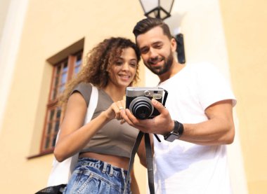 Fotoğraflara bakarak yürüyen genç arkadaşların portresi