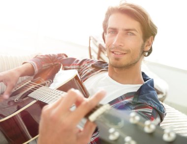 gitar oturma odasında kanepede oturan adam. bir yaşam tarzı kavramı