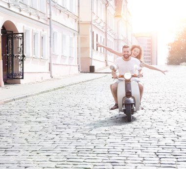 mutlu genç bir çift bir scooter üzerinde eğleniyor