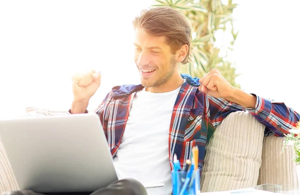 Heureux jeune homme travaillant avec ordinateur portable de la maison . — Photo