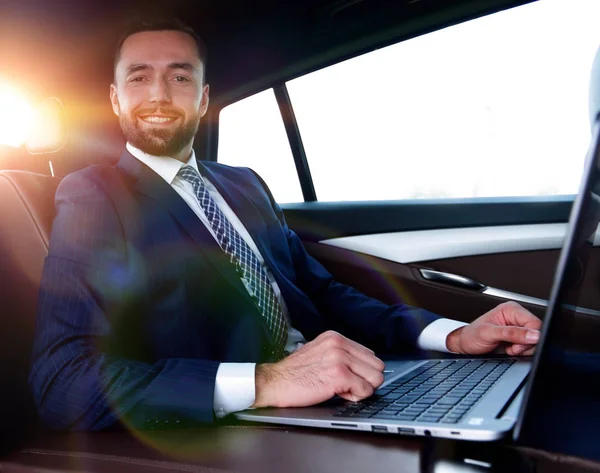 차에 앉아 노트북으로 작업 하는 성공적인 남자 — 스톡 사진