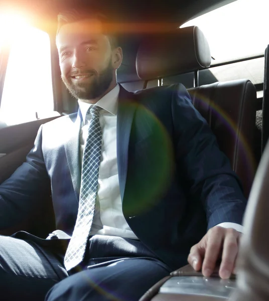 Empresário sentado no banco de trás de um carro — Fotografia de Stock