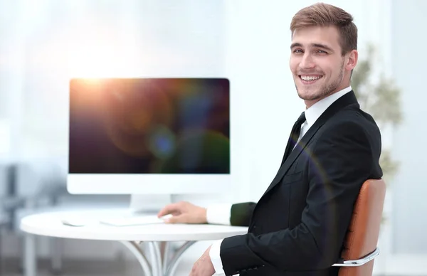 Framgångsrik affärsman sitter vid skrivbord och tittar på kameran. — Stockfoto