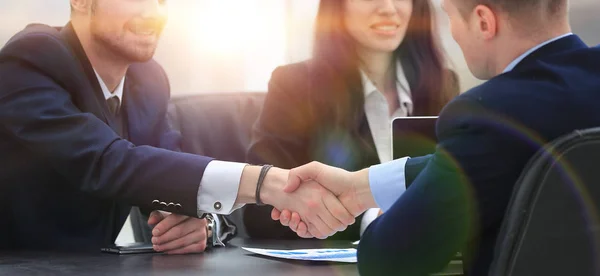 Handslag finansiella partner sitter vid bordet — Stockfoto