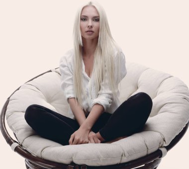 büyük bir rahat tekli koltukta oturan güzel genç kadın.