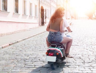 mutlu genç bir çift bir scooter üzerinde eğleniyor