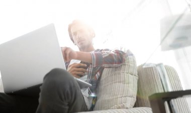 fotoğraf genç adam ile smartphone bir sandalyede oturuyor. bulanık bir arka plan üzerinde