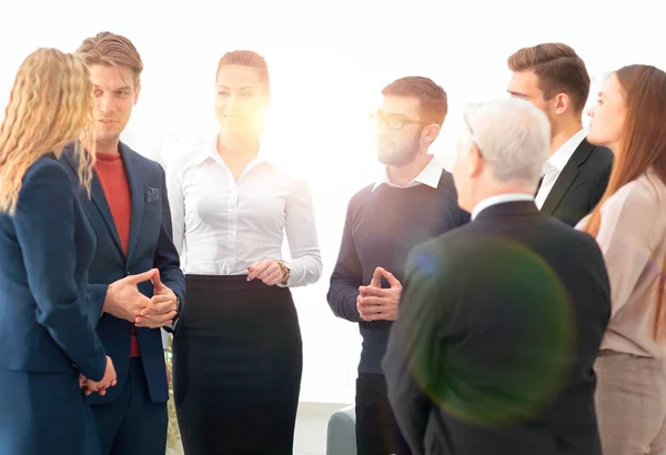 Exitoso equipo de negocios discutiendo documentos e ideas de pie cerca de escritorio — Foto de Stock