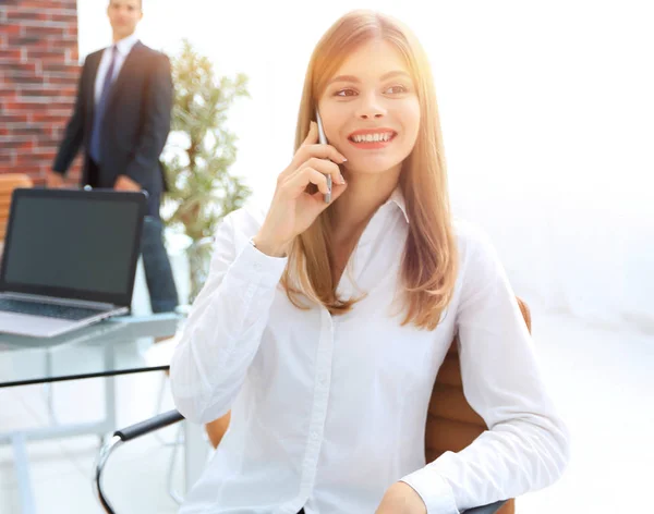 Close seup.female assistant talking on mobile phone in office — стоковое фото