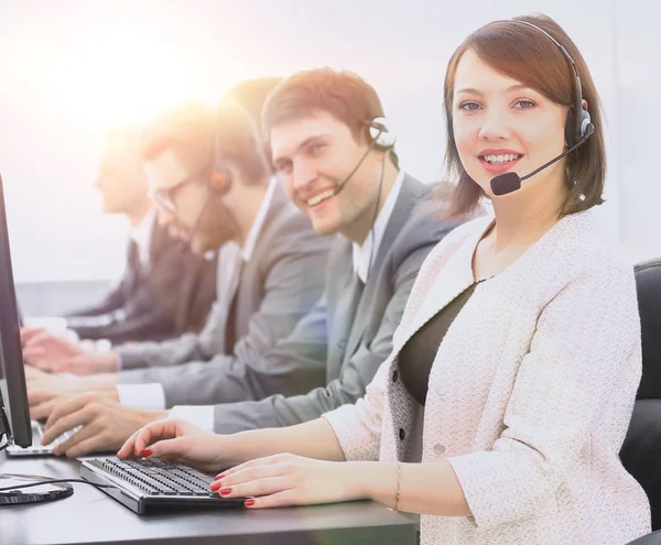 Female customer service representative and colleagues in the call center — Stock Photo, Image